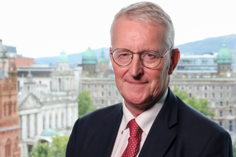 Secretary of State, Hilary Benn MP standing with Belfast City Hall in the background.