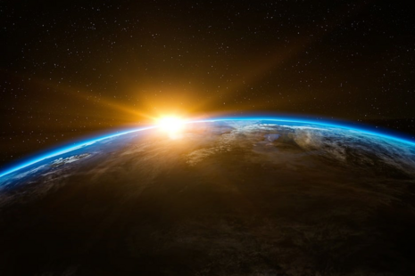 Sunrise viewed from space over the Earth's horizon.