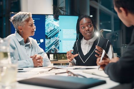A group of people sitting around a table discussing AI.