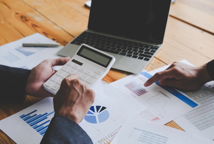 Man with calculator and latpop. Credit: Shutterstock