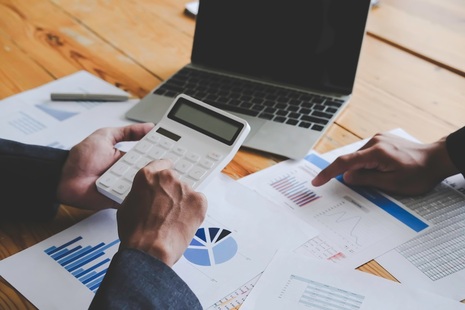 Man with calculator and latpop. Credit: Shutterstock