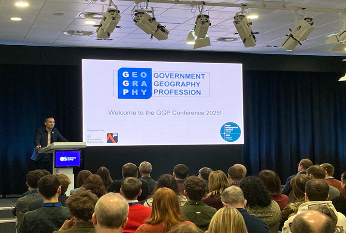 David Wood , Head of the GGP standing at a lecturn addressing the conference