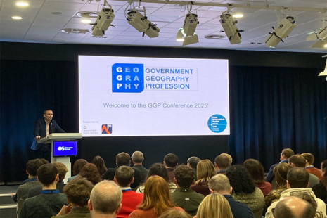 David Wood , Head of the GGP standing at a lecturn addressing the conference