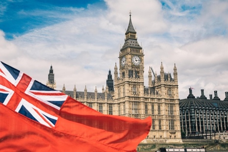 Red Ensign flag flying in front of the Houses of Parliament.