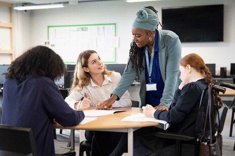 A teacher with some students in a school classroom