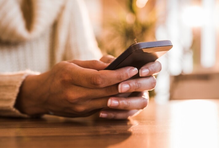 Hands typing into a mobile phone