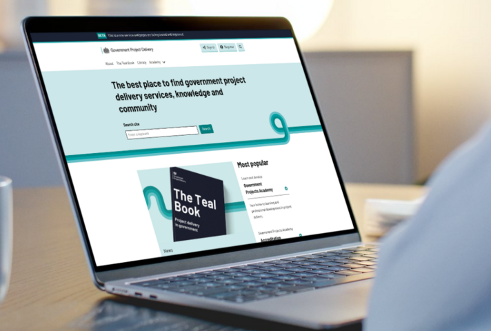 Person using a laptop displaying a GOV.UK webpage about government project delivery services.