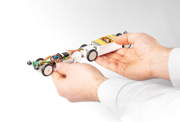  ‘PipeINEER’ small autonomous robot held in operator's hand.