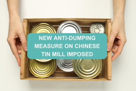 Hands holding a wooden crate filled with metal food cans. Overlaid in a teal banner, text states: "New anti-dumping measure on Chinese tin mill imposed"