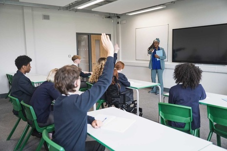A teacher with some students in a school classroom