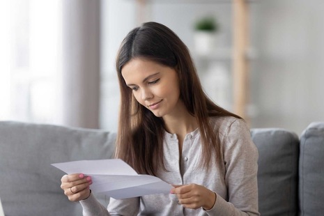 A young female student reading her qualification results