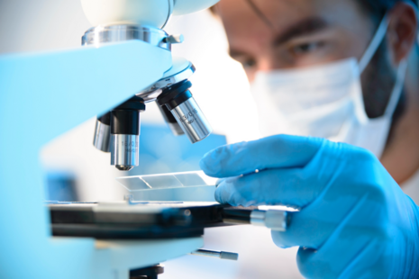 Scientist putting a slide under a microscope