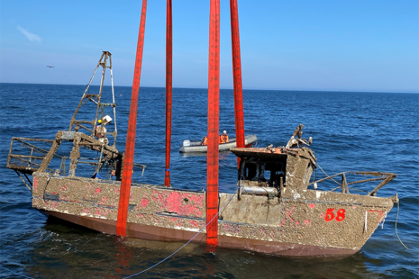 looking towards the starboard side of the wreck as it is hoisted from the sea.