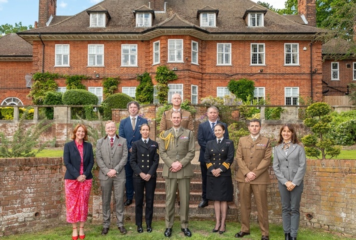 Group of people standing in the gardens of a large house