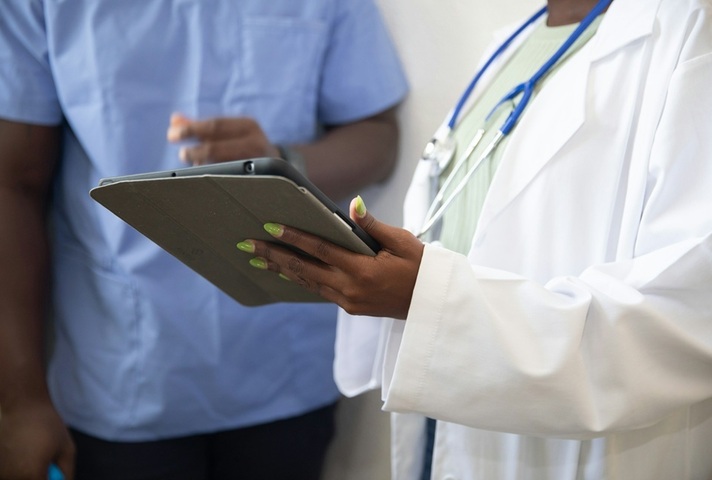 Dr with tablet speaks to nurse. Credit: Unsplash