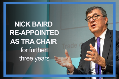 Promotional graphic with a blue border. On the right, a suited speaker gestures while seated on stage. On the left, white text on a teal and grey background reads: “NICK BAIRD RE-APPOINTED AS TRA CHAIR,” with smaller text: “for further three years.