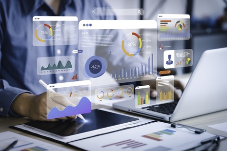 People typing at laptops with data images floating above. Credit: iStock Photo
