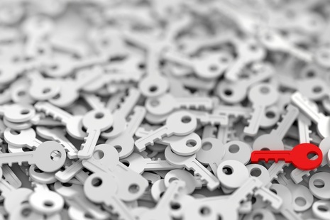 One red key in a pile of white keys. Credit: Shutterstock.