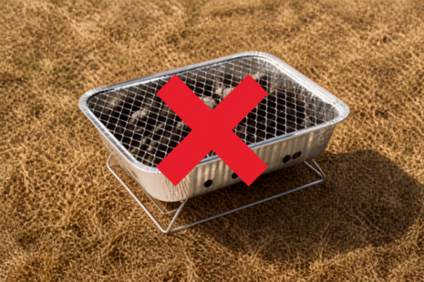Disposable BBQ on dry grass