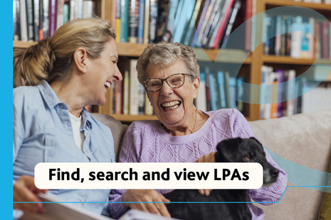 Women laughing together while one has a black dog on her lap