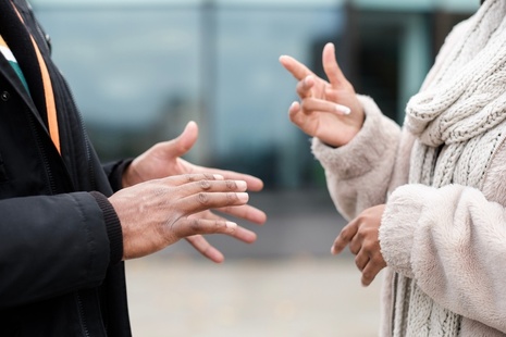 The hands of 2 people conversing with sign language 
