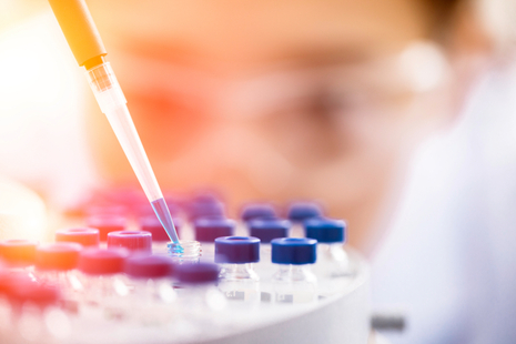 Close up of laboratory worker using a pipette. 